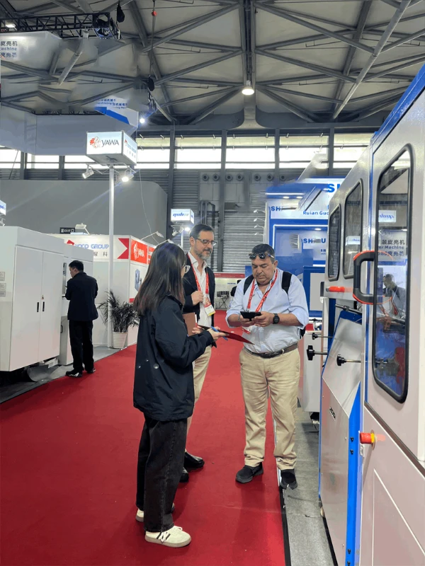 Visitors discussing Automatic Case Maker at the exhibition booth